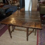 An early 19th century oak drop leaf, gate leg, dining table.