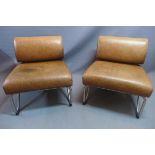 A pair of 20th century tan leather chairs, raised on steel supports.