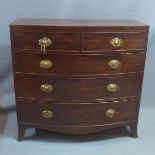 A Regency mahogany bow fronted chest of two short over three long drawers, with rosewood cross
