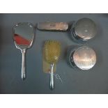 An Edwardian silver mounted dressing set, to include two brushes, mirror and two cosmetic jars.