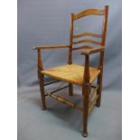 A 19th century oak armchair, with rush seat, raised on turned legs joined by stretcher.