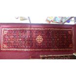A fine North West Persian Malayer runner, 285cm x 95cm, repeating heratie motifs on a rouge field