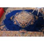 A large Chinese woolen carpet with central floral medallion on a blue ground contained by floral