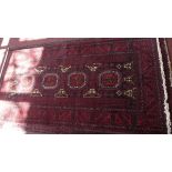 A fine North East Persian Zabul Belovch rug, repeating elephant foot motifs on a rouge field