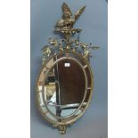 A 19th/20th century Chippendale style oval gilt wood mirror, with carved eagle and floral crest,
