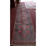 A fine North West Persian Senneh runner, repeating stylised pole medallion all over on a rouge field