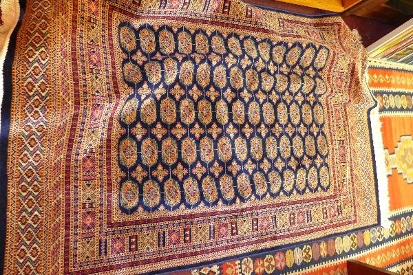 A Bokhara style rug, with elephant pad motifs, on a blue ground, contained by geometric borders, 190