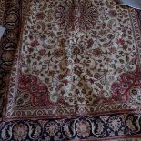 A Kashan style carpet, with central floral medallion on a beige ground, contained by floral borders,