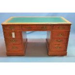 An Edwardian oak pedestal desk, having green leather skiver, with arrangement of nine drawers,