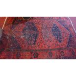 A red ground Afghan rug, having central geometric medallions, 200 x 132cm