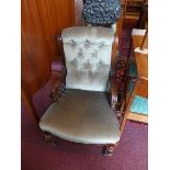 A Victorian mahogany armchair, having buttoned green velour upholstery, raised on turned legs and