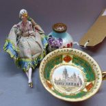 A pin cushion in the form of a 1920's Flapper girl, having porcelain body and legs, together with