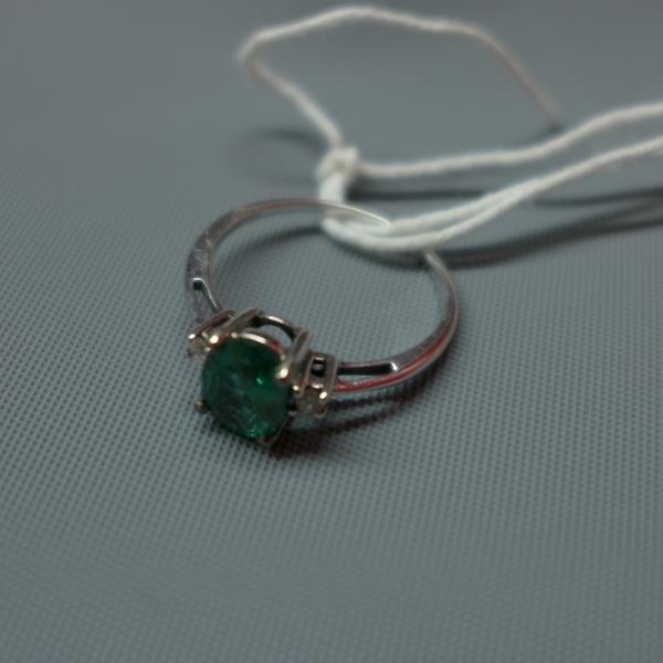 A ladies 9ct white gold ring, inset with possibly tourmaline to center flanked by two round cut