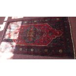 A fine North East Persian Meshad Belovch rug, having central double pendent medallion on a rouge