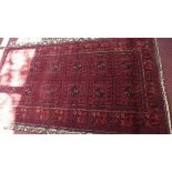 A fine North East Persian Turkoman rug, repeating panel motifs on a rouge field within stylised