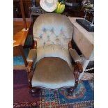 A Victorian mahogany spoon back armchair, having buttoned green velour upholstery, scroll arms,