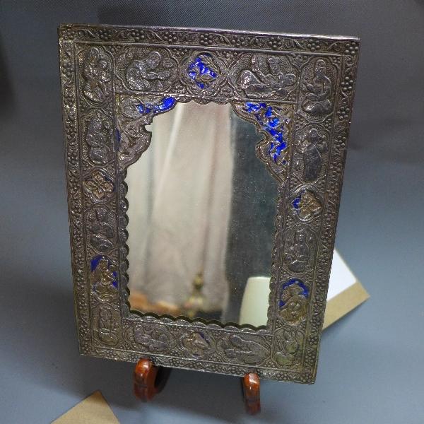 A Persian white metal mirror, raised on hardwood stand