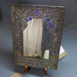A Persian white metal mirror, raised on hardwood stand