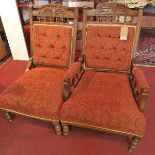 A pair of carved oak framed chairs with red upholstery