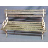 A two seat garden bench, with weathered teak slats, raised on white painted cast iron supports