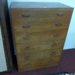 A mid 20th century teak pedestal dressing chest, with hinge top enclosing mirror, above five