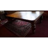 A 19th century Continental oak dining table with three extra leaves, the carved and moulded top