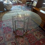 A Merrow & Associates dining table, with glass top, raised on chrome base, H. 74 Diameter 117cm