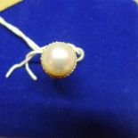A ladies 18ct gold ring, inset with central pearl flanked by diamonds, marked 750, size M 1/2