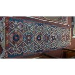 An antique Kelim runner, with eight geometric pole medallion, on a red and blue ground, contained by