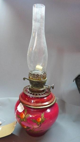 An early 20th century ceramic oil lamp raised on cast metal base, H.56cm (a/f)