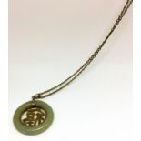 A Chinese 9ct yellow gold and jade pendant, having gold character to central within jade band,