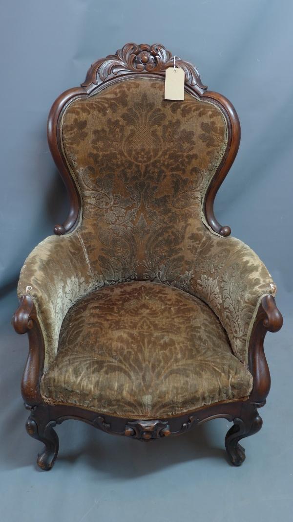 A Victorian mahogany armchair, with damask upholstery, raised on cabriole legs