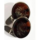 A pair of white metal and intaglio carnelian cufflinks, the carnelians finely carved with faces, (