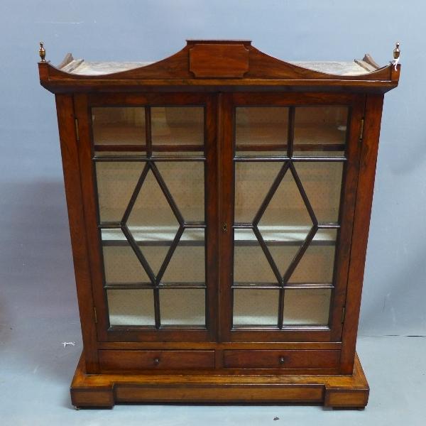 A 19th century rosewood table top bookcase, with two glazed doors over two drawers, raised on plinth