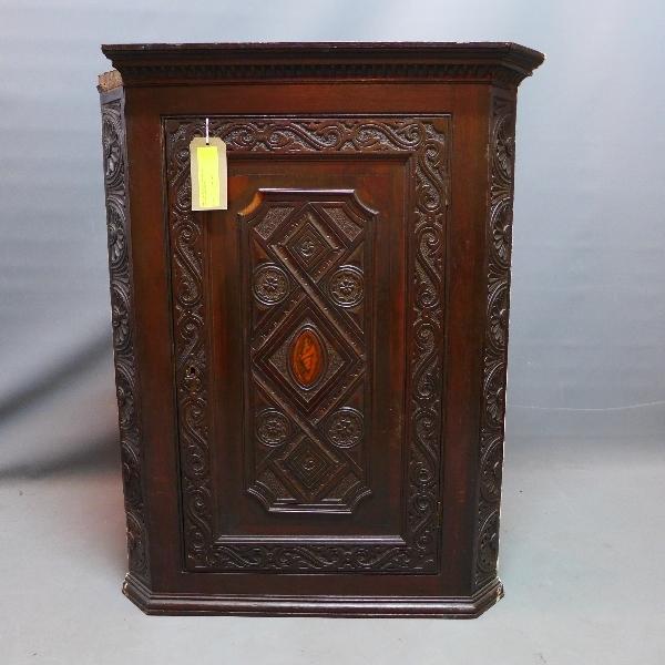 An 18th/19th century carved oak corner cabinet, with inlaid shell patera