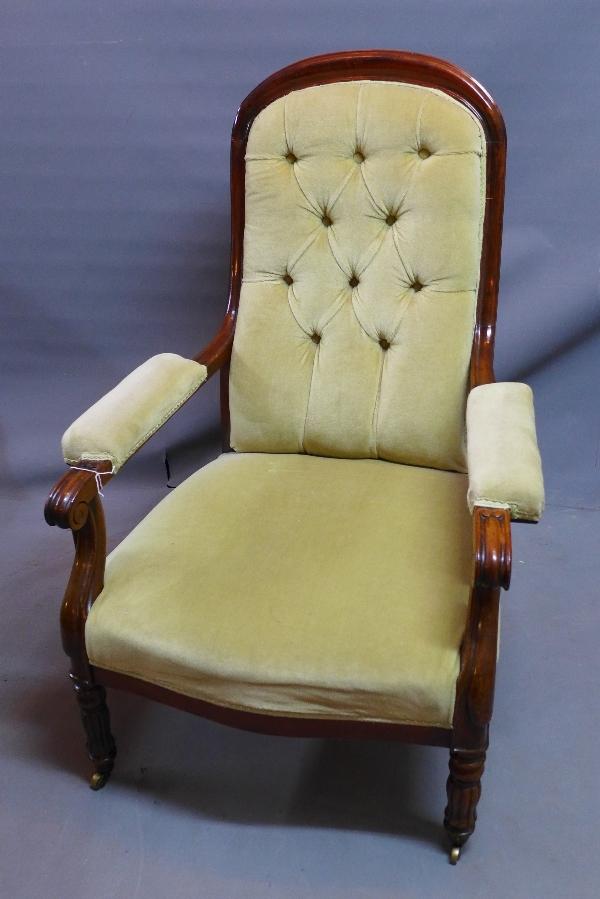 A William IV mahogany armchair, with button back velour upholstery, raised on fluted legs and