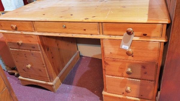 A 20th century pine pedestal desk, with eight drawers, H.77 W.136 D.64 cm