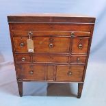 A Regency mahogany campaign dressing chest, with hinged lid enclosing mirror, above brush slide,