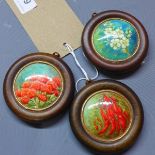 Three early 20th century hand painted miniature studies of flowers in circular oak frames,