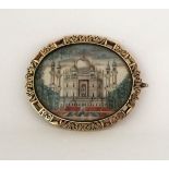 A miniature ivory and yellow metal brooch, inset with oval shaped ivory, hand-painted with the Taj