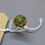 A ladies yellow metal dress ring, inset with green stones
