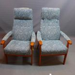 A pair of mid 20th century teak armchairs, with blue leaf pattern upholstery, raised on tapered legs