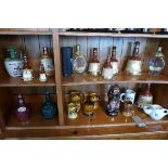 A collection of nine Wade ceramic whiskey bottles, plus others, together with a musical decanter