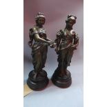 A near pair of late 19th century cast bronze figurines of Classical ladies carrying fruit and