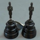 A pair of bronze Egyptian figures, raised on ebonized stands