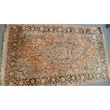 An Indian part-silk rug, central floral medallion on a pink ground contained by floral borders,