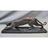 A cast bronze study of a leopard, raised on rectangular stepped marble base, H.23 W.63cm