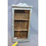 An Indian blue painted teak cabinet, having glazed door and two shelves, H.64 W.33 D.11cm