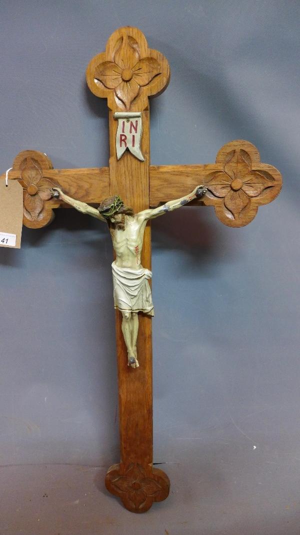 An early to mid 20th century Continental oak crucifix, carved with flowers, with painted aluminium