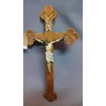 An early to mid 20th century Continental oak crucifix, carved with flowers, with painted aluminium